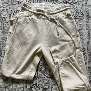 Cream Fabletics cuffed sweatpants with 2 side pockets and 1 back pocket
